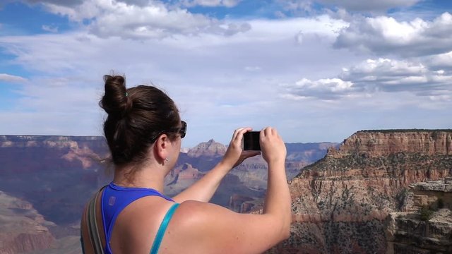 Woman taking picture of grand canyon in usa in slow motion 250fps