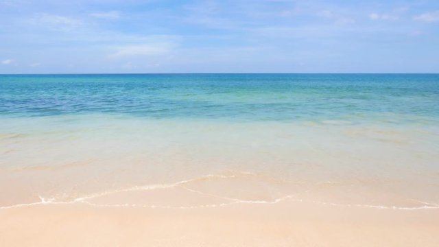 Medium wide video of waves at a beautiful clean beach during daytime