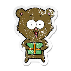 distressed sticker of a laughing teddy  bear with christmas present