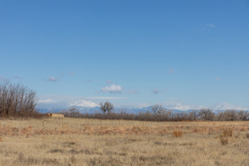 Field and hay bale with Longs Peak in the background, from Rocky Mountain Arsenal, Colorado.