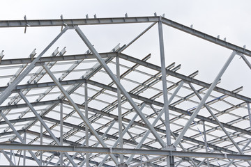 Structure of building from galvanized metal. Steel construction on sky background. Metal galvanizing technology to prevent corrosion.
