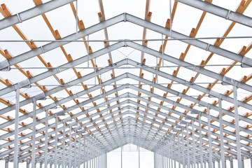 Wooden beams on a metal frame. Construction of agricultural buildings. The construction of the barn. Agriculture.