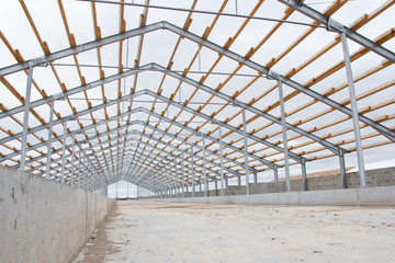 The construction of the new barn. Wooden beams on a metal frame. Construction of agricultural...