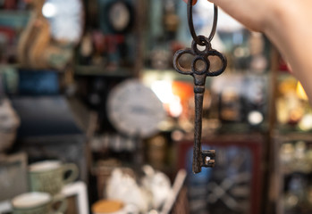 woman's hand holding an antique key on blurred background