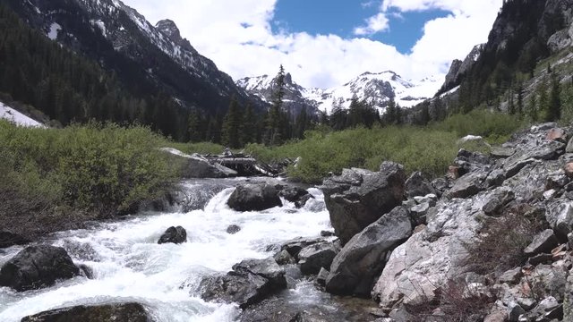White water on a river rushing down from the snowy mountains on a cloudy day