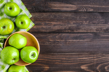 Ripe green apples and apple slices on old wooden background. Place for text. Top view