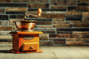 Vintage coffee grinder, turk copper coffee pot and coffee beans on wooden background