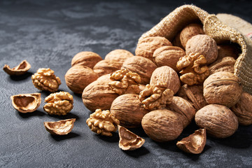 Walnuts in bag on black background with copy space.
