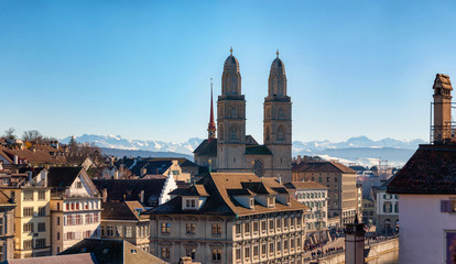View on romanesque-style Grossmunster (Great Minster) and Zurich city center with Alps in the...