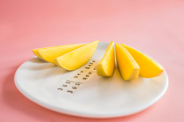 Mango fruit and mango slices on the white plate.