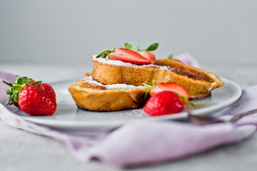 French toast with strawberries. Gray background, side view, space for text