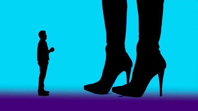 Woman and high-heeled boots dominate a pleading man and kick him dan with the shoe tip away.