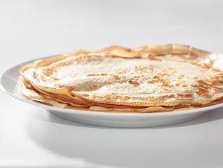 thin pancakes on white dish isolated on white background, selective focus