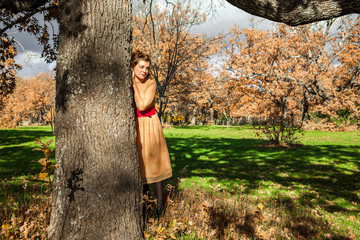 Portrait elegant young woman standing up in a tree. Thoughtful. In love. Environmental