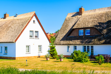Fototapeta na wymiar Traditional houses with thatched roofs on street in Gager village, Ruegen island, Baltic Sea, Germany