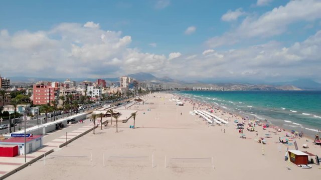 Descending aerial shot of San Juan beach in Alicante, Spain with empty beach volleyball courts