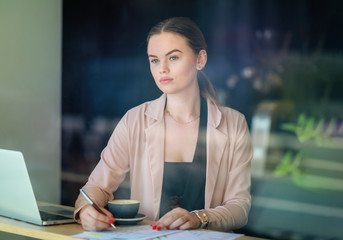 Elegant business woman looking through the window in a cafe shop. Thoughtful Look. Selective focus and reflexion on window