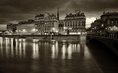 Paris by night.Nocturne view of beautiful Parisian buildings of Ile de la Cite and Seine river. Black and white scenic spot photo.