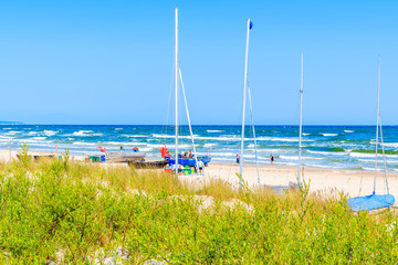 BAABE BEACH, RUGEN ISLAND - MAY 31, 2018: Tourists walking among fishing and sailing boats on sandy beach in Baabe village, Baltic Sea, Germany.