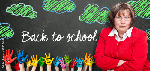 Lehrerin vor Wandtafel mit Aufschrift "Back to school"