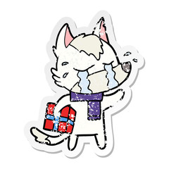 distressed sticker of a cartoon crying wolf with christmas present