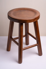 Handcrafted dark brown wooden backless stool on white background isolated