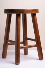 Handcrafted dark brown wooden backless stool on white background isolated