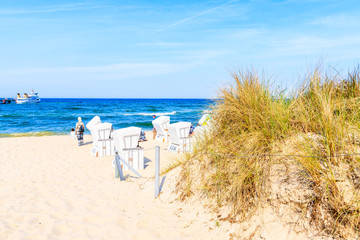 Wicker chairs on sandy beach in summer, Baabe village, Baltic Sea, Germany