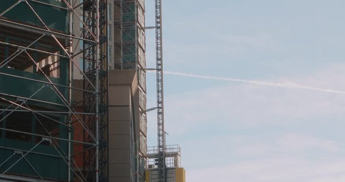 Construction lift goes up side of skyscraper being built.