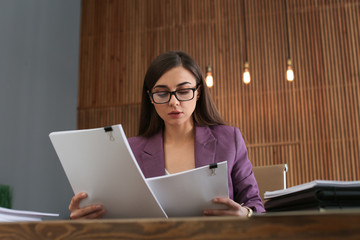 Beautiful businesswoman working with documents at table in office