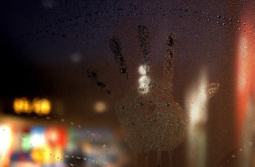 Hand print on a steamy wet window.