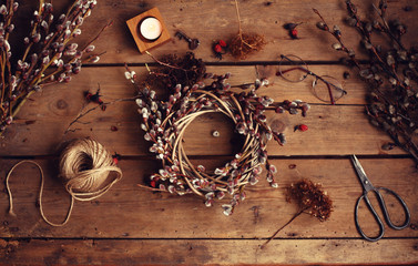 Spring or Easter background.Easter Wreath,willow branches,glasses,scissors,thread.Flat lay /view from above