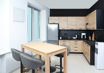 Fototapeta na wymiar Cozy modern kitchen interior with new furniture and appliances