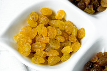 golden and brown raisins on plate. Top view of dried grapes.
