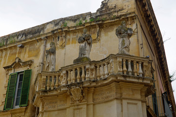Fototapeta na wymiar Charming balcony with baroque statues as example of typical architecture in Lecce in the Apulia region, Italy