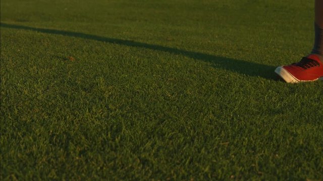 A golfer hitting a ball terribly and it bounces a few feet on a golf course.