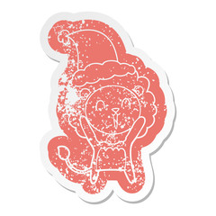 laughing lion cartoon distressed sticker of a wearing santa hat