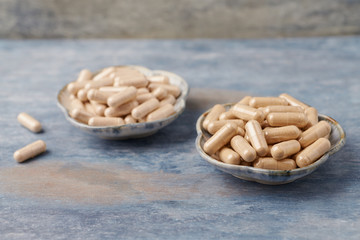 Ashwagandha  (Withania somnifera) and Korean Ginseng capsules.  Concept for a healthy dietary supplementation. Rustic wooden background. Copy space. 