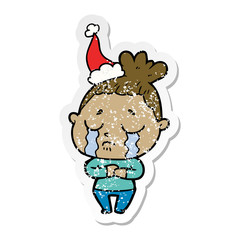 distressed sticker cartoon of a crying woman wearing santa hat