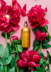 Red fresh peonies and perfume bottles