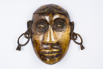Close-up of a Naga tribal face in bronze from the Nagaland region. Isolated on white background