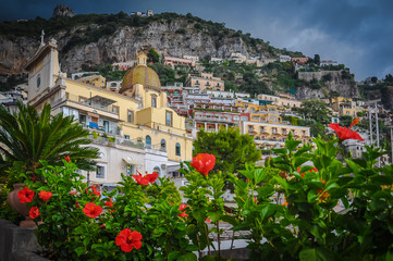 Fototapeta premium Red flowers with church background in Positano village