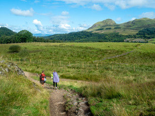 Obraz premium two girls hiking in sunny weather in scotland