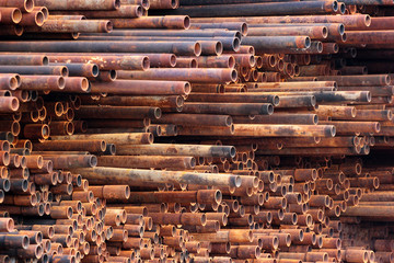 Pile of rusty metal pipes as industrial background