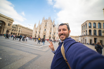 Happy tourist traveling in Italy take selfie photo in front of Milan Cathedral. Self portrait of beautiful tourist backpacker in the capital of fashion Milan, Italy.