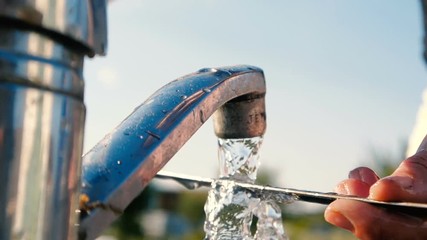 Lengthy skewer washed by female hands over a sink in a garden in slo-mo