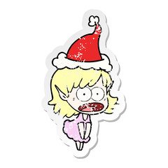 distressed sticker cartoon of a shocked elf girl wearing santa hat