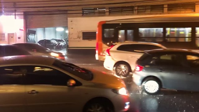 Cars Passing by Rainy Night in city street, water drops. Traffic Light. S&atilde;o Paulo, Brazil, Marc, 02, 2019