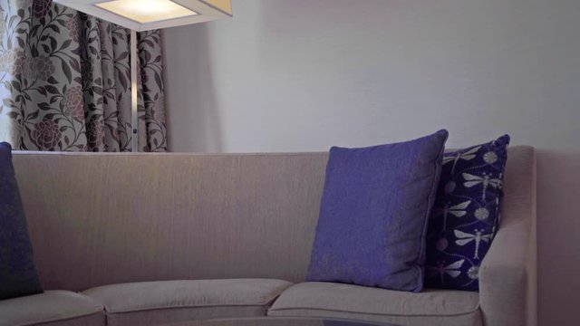 Patterned cushions on sofa next to wooden table and interior light with a adorable curtains interior design concept