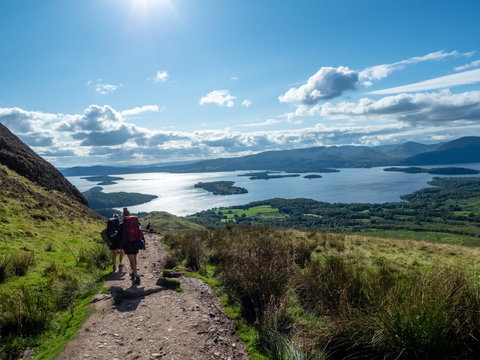  two girls hiking with beautiful lake (loch lomond) and green landscape